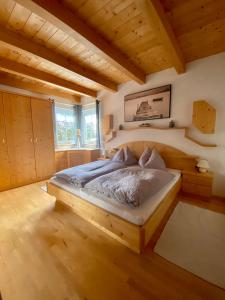 een slaapkamer met een bed in een kamer met houten plafonds bij AlpenApartment in Bramberg am Wildkogel