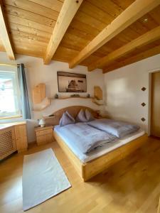 a bedroom with a bed and a wooden ceiling at AlpenApartment in Bramberg am Wildkogel