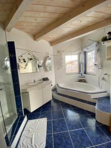 een grote badkamer met een bad en een wastafel bij AlpenApartment in Bramberg am Wildkogel