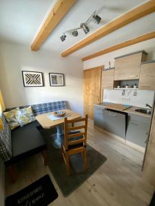 ein Wohnzimmer mit einem Tisch und einer Küche in der Unterkunft AlpenApartment in Bramberg am Wildkogel