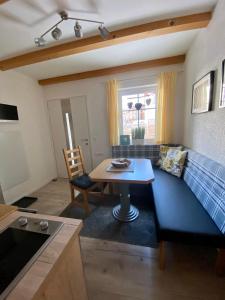 a living room with a blue couch and a table at AlpenApartment mit NationalparkCard in Bramberg am Wildkogel +21 photos
