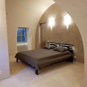 a bedroom with a bed in a room with an arch at Bastide au coeur du Lubéron in Gordes