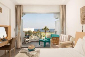 a living room filled with furniture and a window at Kolymbia Bay Art - Adults Only in Kolymbia