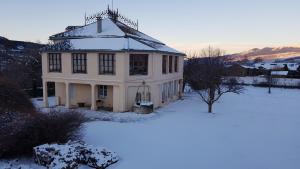 una casa blanca con nieve en el suelo en Le petit manoir de Palau, en Palau-de-Cerdagne