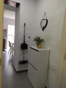una cucina bianca con un mobile con una pianta sopra di Moya, Senderos y naturaleza a Moya