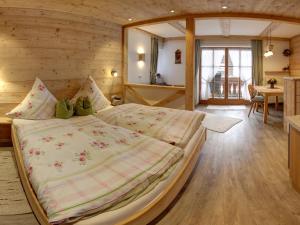 Cette chambre en bois comprend un grand lit. dans l'établissement Beim Bretzner - Chiemgau Karte, à Inzell