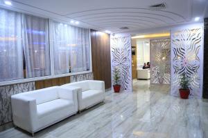 un soggiorno con divano bianco e alcune piante di The Ravindram Hotel a Bhiwadi