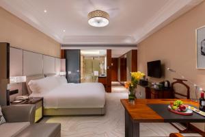 a hotel room with a bed and a living room at Sofitel Hangzhou Westlake in Hangzhou
