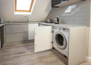 a kitchen with a washing machine and a sink at Spacious New One Bed Flat in the Heart of Reading in Reading