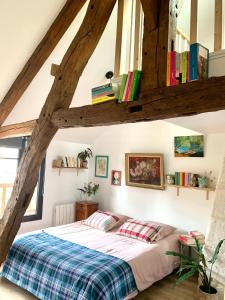 ein Schlafzimmer mit einem Bett mit Büchern an der Wand in der Unterkunft Maison Léontine in Bernay