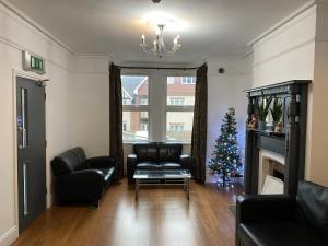 a living room with a christmas tree and leather chairs at Buckingham Hotel in High Wycombe