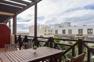 a wooden table on a balcony with a view of the beach at Sunset in paradise in Cotillo