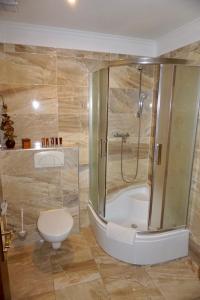 y baño con ducha, aseo y bañera. en Penzion Vegas, en Partizánske