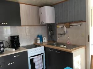 a kitchen with a white stove and a sink at Ferienbungalow Karnitz/Rügen in Karnitz