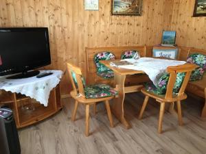 a dining room with a table and chairs and a tv at Ferienbungalow Karnitz/Rügen in Karnitz