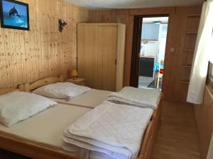 two beds in a room with wooden walls at Ferienbungalow Karnitz/Rügen in Karnitz