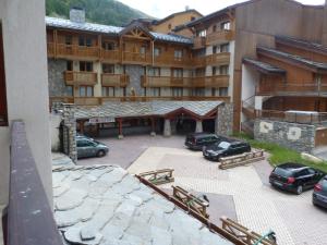 a view of a building with cars parked in a parking lot at Val-d'Isère - 2 pièces + cabine au pied des pistes in Val dʼIsère