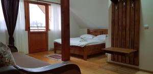 a small bedroom with a bed and a window at Pensiunea Printul Vlad in Sibiel