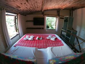 1 dormitorio con 1 cama con manta roja en Pousada Ibirapuera, en Jericoacoara