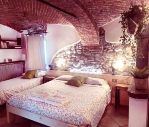 una camera con due letti e un muro di mattoni di Lu Garun Rus a Valdieri