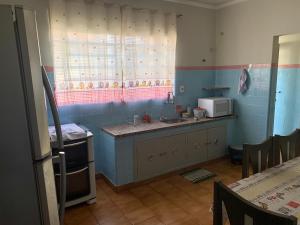 a kitchen with a sink and a microwave at Casa Familiar Proença 15 solteiros ou 21 se 2 nas camas de casais in Campinas