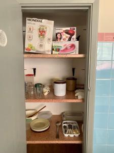 a cupboard filled with dishes and other kitchen items at Casa Familiar Proença 15 solteiros ou 21 se 2 nas camas de casais in Campinas +13 photos