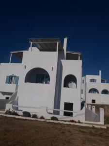 a white building with two large windows on the side of it at Agiassos Naxos Apartments in Agiassos