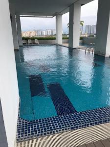 a swimming pool with blue water in a building at KLCC view - Jalan Kuching Boulevard Service Apt in Kuala Lumpur