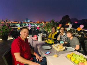 a group of people sitting at a table with food at Li River Resort Villa Hotel in Guilin