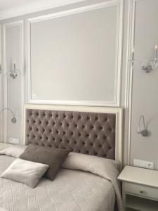 a bed with a padded headboard in a bedroom at Hôtel restaurant Oasis in Nice