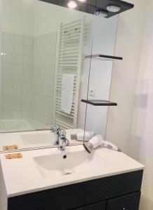 a bathroom with a white sink and a mirror at Le 61 bis in Saint-Valery-sur-Somme
