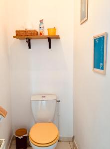 een badkamer met een toilet en een houten stoel bij Le 61 bis in Saint-Valery-sur-Somme