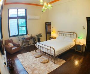 a bedroom with a bed and a chair and a table at Liu Xu Homestay in Tainan
