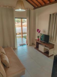 a living room with a couch and a television at Bellíssimo Villaggio in Porto De Galinhas