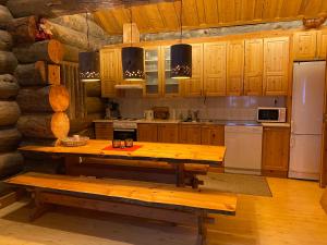 a kitchen with a wooden table and a refrigerator at Levi Log Cabin - Viprakka 4A in Levi