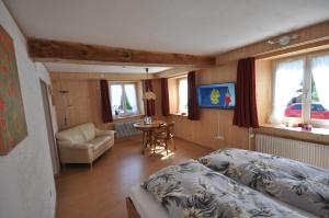 a bedroom with a bed and a chair and a table at Gasthaus Waldheim in Fürstenaubruck