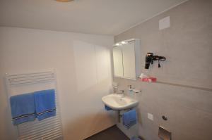 ein weißes Badezimmer mit einem Waschbecken und einem Spiegel in der Unterkunft Gasthaus Waldheim in Fürstenaubruck
