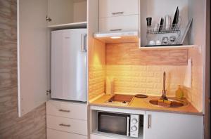 Una pequeña cocina con fregadero y microondas. en Hotel-Home Bed&Bike, en Bila Tserkva 20 fotos más