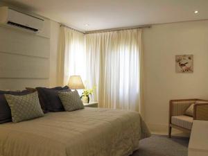 um quarto com uma cama grande e uma janela em Hotel Maui Maresias em Maresias