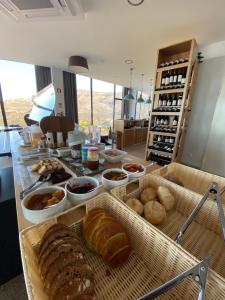 a buffet with bread and other foods on a table at Casas do Pastor in Seia