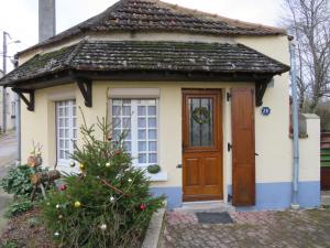 a small house with a christmas tree in front of it at Charmante maison prés de Vézelay in Voutenay-sur-Cure