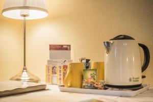 un bollitore per il tè su un tavolo accanto a una lampada di Chambres d'Hôtes Chez Mado Ottrott a Ottrott