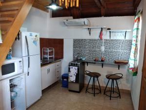 uma cozinha com frigorífico, fogão e bancos em Freecis em Esquel
