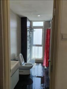 a bathroom with a sink and a toilet and a window at Central residence in Kuala Lumpur