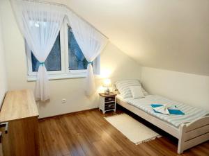 niewielka sypialnia z łóżkiem i oknem w obiekcie Apartmán pod Sivým vrchom w Zuberzcu