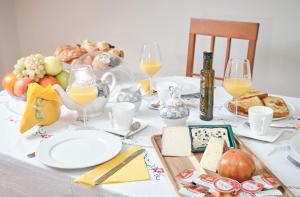 una mesa con comida y copas de vino y queso en Peregrina Pensión 1 en O Pedrouzo