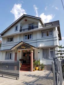 una casa blanca con una valla delante en Duy Hotel, en Da Lat 42 fotos más