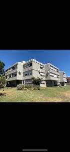 un grand bâtiment blanc au milieu d'un champ dans l'établissement salto grande, à Punta del Este