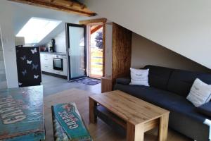 - un salon avec un canapé bleu et une table dans l'établissement Komplette Dachwohnung mit Balkon und Bergblick, à Sonthofen