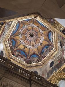 an ornate ceiling of a building with a clock on it at Pensione Delfino Azzurro in Loreto